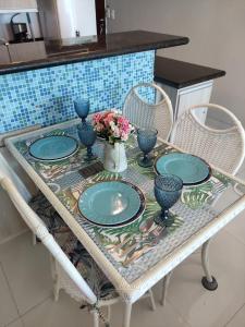 a table with blue plates and vases on it at Mar de Cerejeira in Arraial do Cabo