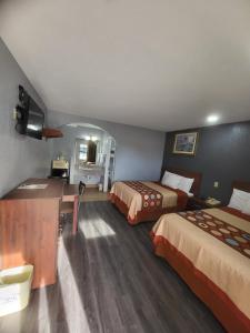 Habitación de hotel con 2 camas y escritorio en Budget Inn Buffalo en Buffalo