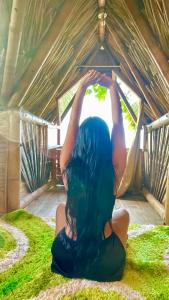 Une femme assise dans une tente avec ses bras dans l'air dans l'établissement Guajira Beach, à Ríohacha