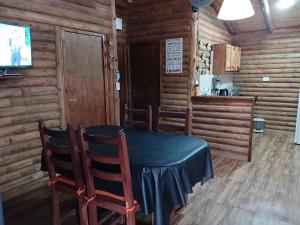 comedor en una cabaña de madera con mesa y sillas en Cabaña Las Marias en Villa Santa Cruz del Lago