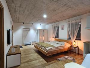 1 dormitorio con 1 cama y suelo de madera en Hajdar en Mattighofen