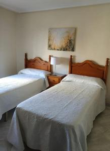 a bedroom with two beds and a lamp on a table at Apartamento acogedor y bien situado in Fuengirola