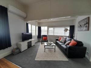 a living room with a couch and a tv at Character 1-Bedroom Unit in Masterton