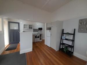 a kitchen with white appliances and a wooden floor at Character 1-Bedroom Unit in Masterton