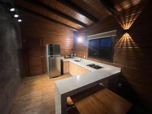 cocina con nevera de acero inoxidable y paredes de madera en Paradouro Monã en Torres