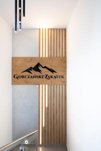 ein Schild an der Wand eines Gebäudes in der Unterkunft Gorczański Zakątek in Konina