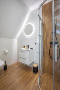 La salle de bains est pourvue d'une douche et d'un lavabo. dans l'établissement Gorczański Zakątek, à Konina