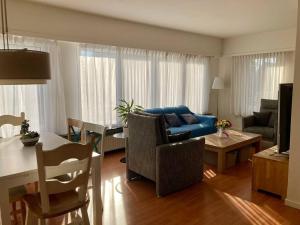 een woonkamer met een blauwe bank en een tafel bij Charming Sunny 100m2 Entire Apartment with 2 bedrooms in Brasschaat