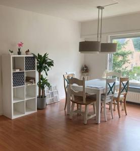 une salle à manger avec une table et des chaises blanches dans l'établissement Charming Sunny 100m2 Entire Apartment with 2 bedrooms, à Brasschaat