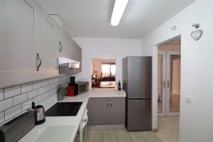a kitchen with a stainless steel refrigerator and white cabinets at La Almadraba 412 in Manilva