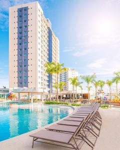 una piscina de hotel con tumbonas y un edificio en Salinas Exclusive Resort en Salinópolis