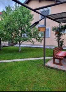 a park bench and a bird house in a yard at APRTMAN SARAJEVO ZA DVIJE OSOBE in Sarajevo