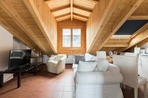 una sala de estar con muebles blancos y techos de madera. en Mortara Navigli Apartments, en Milán
