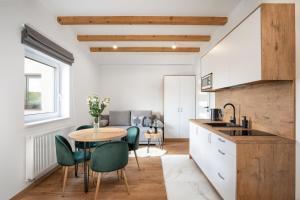 a kitchen with a table and some green chairs at Gorczański Zakątek Jacuzzi & Sauna in Niedźwiedź