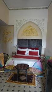a bedroom with a large bed and two chairs at Riad Saida Atlas in Marrakesh