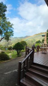 a wooden deck with a table and an umbrella at House of San Sia Ah Kuei in Sanxia