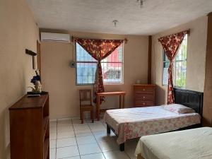 1 dormitorio con 2 camas, vestidor y 2 ventanas en Departamento Foráneo 1, en Concepción