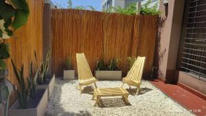 查克拉斯德科里亞的住宿－Chacras de Coria Los Robles，两把椅子和一张长凳在栅栏前