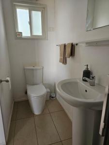 a white bathroom with a toilet and a sink at Warrawong on the Darling Wilcannia Holiday Park in Wilcannia