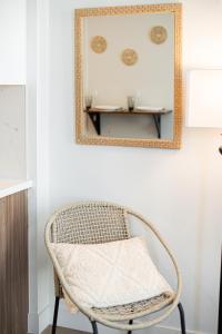 silla de mimbre en una habitación con espejo en Luxury Apartment With The Hollywood Hills View, en Los Ángeles
