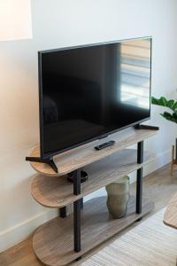 a flat screen tv on a wooden stand in a living room at Luxury Apartment With The Hollywood Hills View in Los Angeles