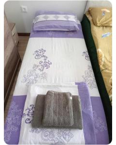 een bed met een paarse en witte deken erop bij Mavrovo Centar Ski Staza in Mavrovo