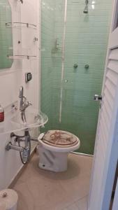 La salle de bains est pourvue de toilettes sales et d'un lavabo. dans l'établissement Apto Pitangueiras vista para o Mar, à Guarujá