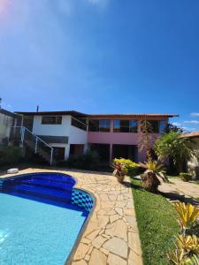 a villa with a swimming pool and a house at Suíte Aconchego 2 in Miguel Pereira