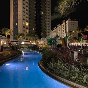 a large blue swimming pool in a city at night at Salinas Exclusive Resort in Salinópolis