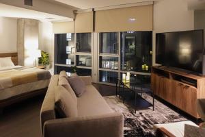 uma sala de estar com um sofá, uma televisão e uma cama em Luxurious Hollywood Dream em Los Angeles