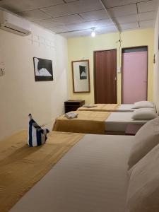una camera con due letti e una porta viola di THE COTTAGE LANGKAWI a Pantai Cenang