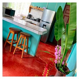 a model of a kitchen with a counter and stools at Casita el jardin in Bijagua