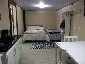 um pequeno quarto com uma cama e uma cozinha em Jardim Temporadas em Canela