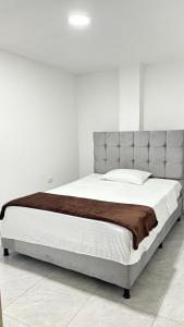 Apto con parqueadero Escalini Mansión Puerta del sol Pitalito في بيتاليتو: غرفة نوم بسرير كبير في غرفة بيضاء