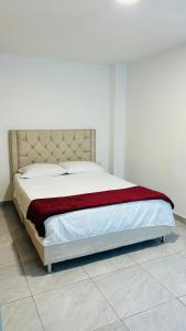 uma cama num quarto com um cobertor vermelho em Apto con parqueadero Escalini Mansión Puerta del sol Pitalito em Pitalito