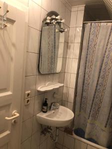 a bathroom with a sink and a mirror and a shower at Privatzimmer in der Nähe vom Düsseldorfer Flughafen in Ratingen
