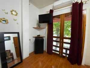 a living room with a window and a television at UFO House in Montañita