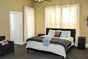 Schlafzimmer mit einem Bett, einem Stuhl und Fenstern in der Unterkunft Historic Highland-Game Room & King Beds in Jackson