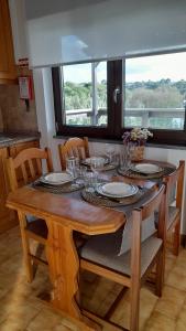 una mesa de comedor con platos y vasos. en Na Rota - Casa de Praia, en Zambujeira do Mar