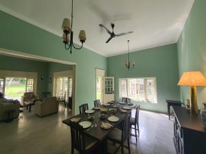 une salle à manger avec une table et un salon dans l'établissement Lewella House Kandy, à Kandy