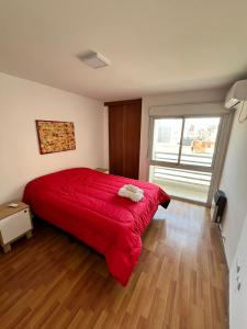 1 dormitorio con cama roja y ventana grande en Jardines del Boulevard 5 en Córdoba