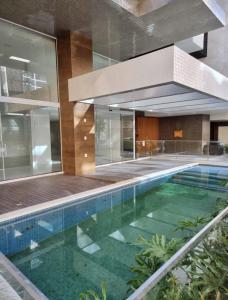 an indoor swimming pool in a building with a house at Apto decorado e bem localizado in Capão da Canoa