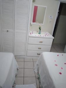 a bathroom with two beds and a dresser with a mirror at Hilltop View Guesthouse in Castries