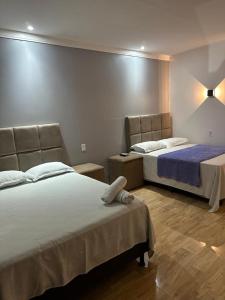 una habitación de hotel con 2 camas en una habitación en Pousada vista alegre en Itaberaba