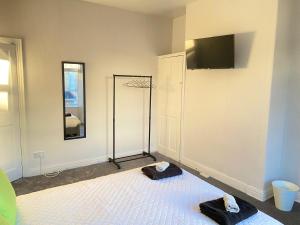 um quarto com uma cama e uma televisão na parede em Kisobi Home Bedroom 1 em Hull