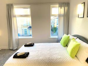een slaapkamer met 2 handdoeken op een bed en 2 ramen bij Kisobi Home Bedroom 1 in Hull