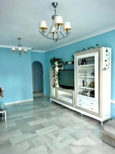 a living room with a white cabinet and blue walls at Casa Caracol in La Herradura
