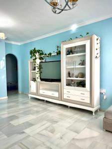sala de estar con armario blanco y paredes azules en Casa Caracol, en La Herradura