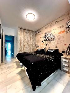 Un dormitorio con una cama negra y una pared con dibujos. en Casa Caracol, en La Herradura