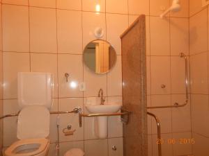 a bathroom with a toilet and a sink and a mirror at Pousada Xodó da Praia in São Pedro da Aldeia +28 photos